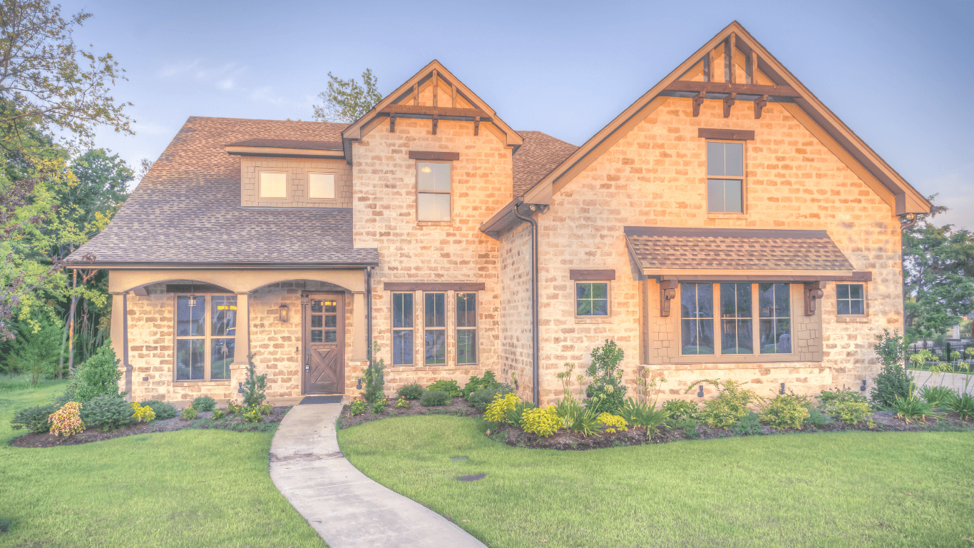 Beautiful brick house with green lawn and trees.