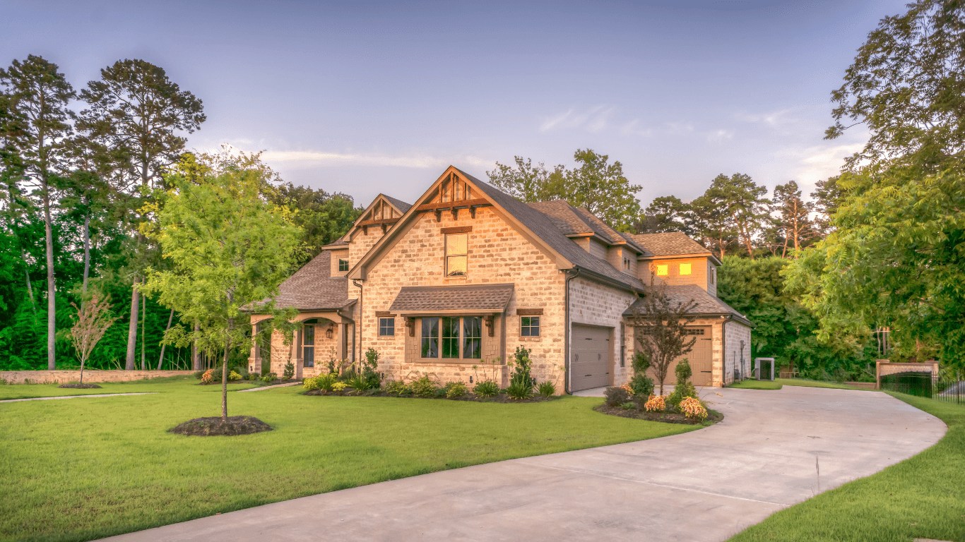 Beautiful brick house with green lawn and trees.